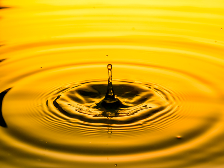 close up of a drop oil on a yellow background
