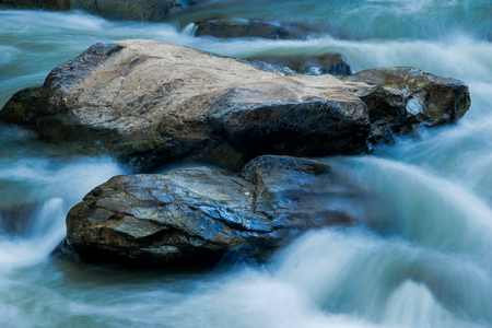 creek flowing over the rocksの写真素材