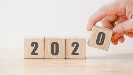 2020  New year countdown design concept , hand holding wood blocks cubes on wooden table  backgroundの写真素材