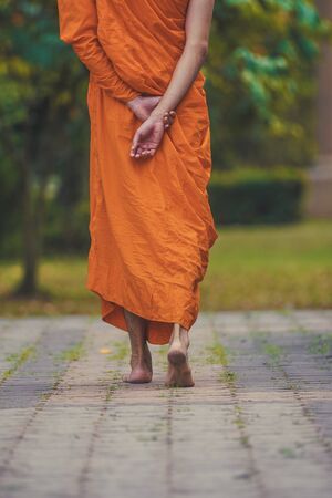 a monk walk meditation around temple in thailand