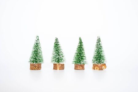 Group of small artifician Christmas tree on nature wooden table on white background, decorate christmas concept.の写真素材
