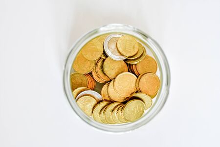 Top view amount euro coins in different price in trasparent bottle on white background. Buisiness and finance conept. Selective focus, flat lay.の写真素材