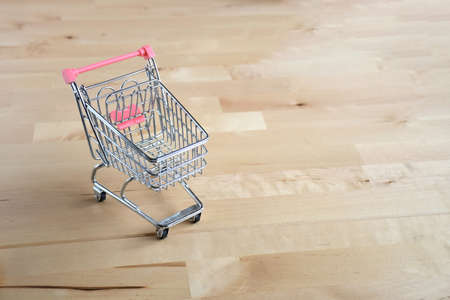 Small mini cart and pink paper bag on white background with space for text. Shopping online and buisiness concept.の写真素材