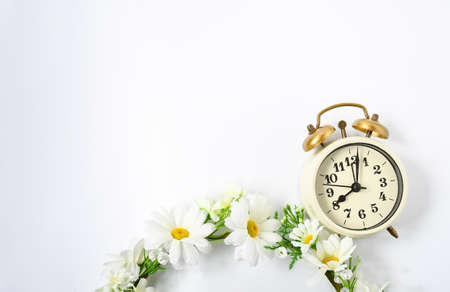 Selective focus vintage alarm clock  with beautiful bouquet flowers  on white background. Love...