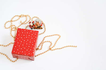 Christmas gift box wrap with red star paper on golden necklace on white background with space for...