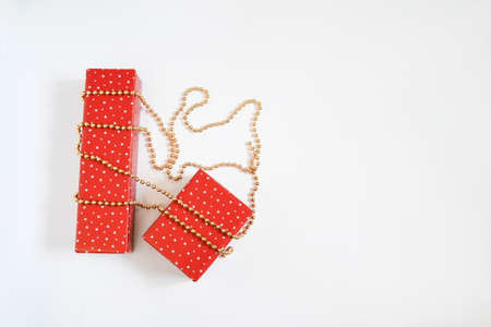 Christmas gift boxes wrap with red star paper on golden necklace on white background with space for text. Handmade objects , Christmas holiday concept.の写真素材