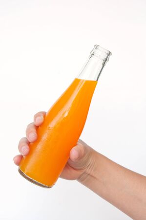 orange juice bottle in hand isolated on white backgroundの写真素材