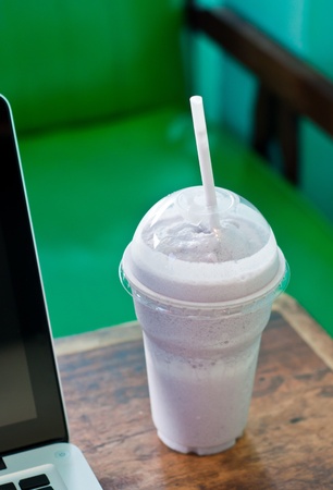 blue berry smoothies and laptop in the cafeの写真素材