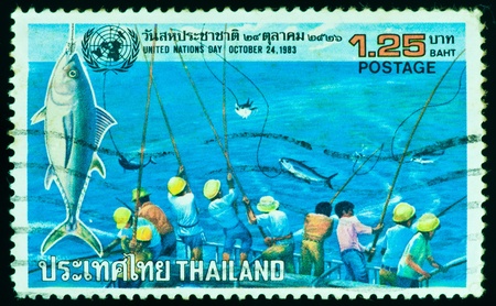 THAILAND - CIRCA 1983: a stamp printed by Thailand, shows people fishing in United Nations Day, circa 1983の写真素材