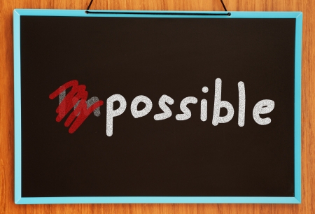 word impossible turning into possible on chalkboard background