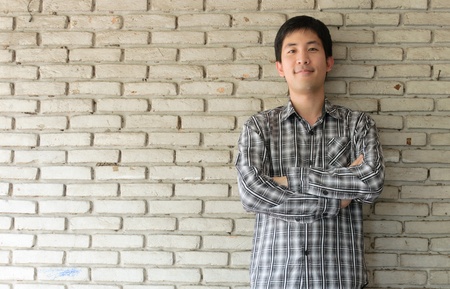 portrait of an asian man with old wall backgroundの写真素材