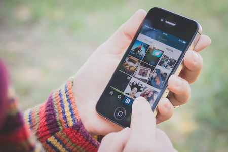 UBON RATCHATHANI, THAILAND - JANUARY 1, 2015: Hand holding Iphone and using Instagram application, Instagram is a popular online social networking service.のeditorial素材