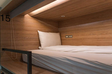 Interior of a hotel room with a wooden bed and a bedside table