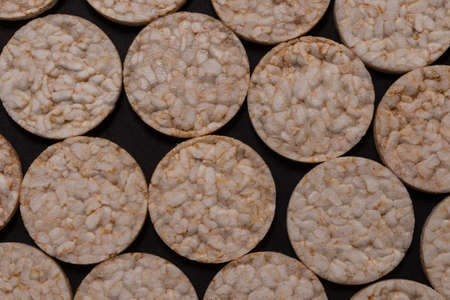 Pattern distribution of rice crackers. Round rice crackers, spread out on a black background. Front...