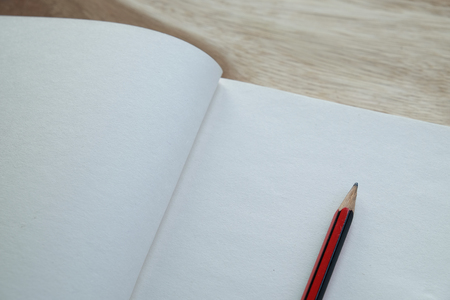 Open a blank white notebook with pencil on wooden tableの写真素材