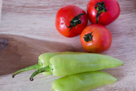Fresh tomatoes and peppers on woodの写真素材
