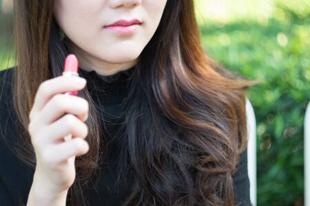 Woman using cosmetic for make-upの写真素材