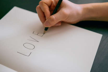 Hand writing love on blank bookの写真素材