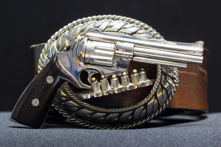 Brown leather buckle made of metal carved into the gun.