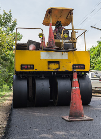 machine and worker at road construction