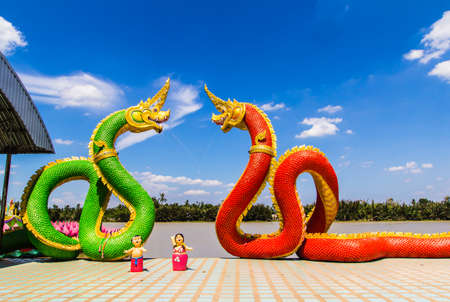 The Big Naga snake guarding Thai temple with white cloud and blue sky backgroundの写真素材
