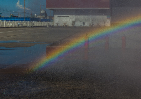 Rainbow on the field , Caused by sunlight on water.の写真素材
