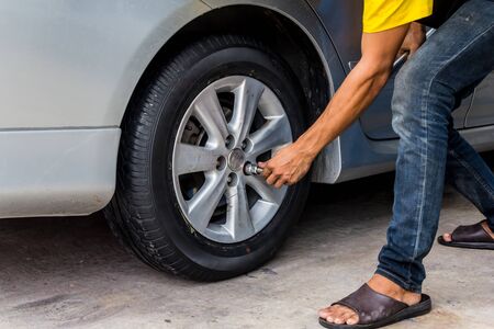 Car wheel change by mechanic closeupの写真素材