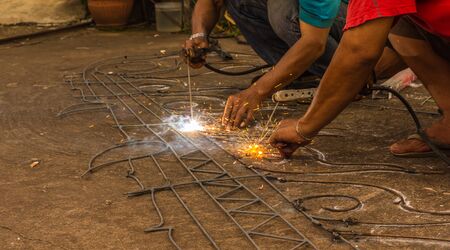 welder working with electrode in arc welding in construction outdoors