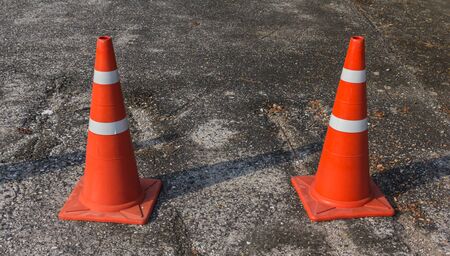 orange cones stand on gray asphalt road