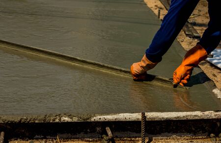 Construction worker spreading wet poured concreteの写真素材