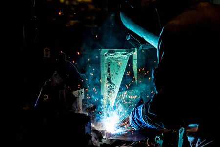 worker with protective mask welding metal