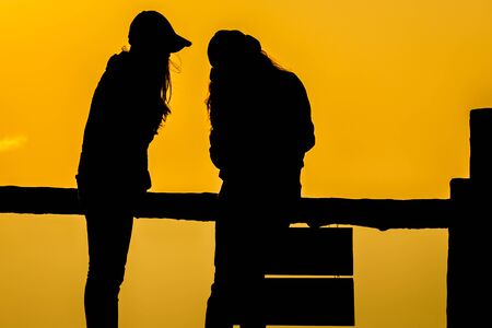 Silhouette of people having fun at sunset timeの写真素材