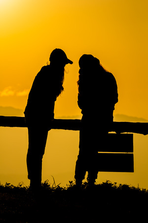 Silhouette of people having fun at sunset timeの写真素材