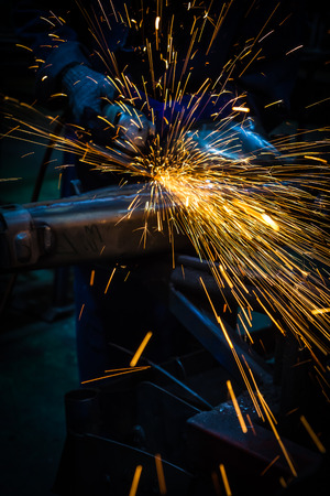 Industry worker cutting metal with grinderの写真素材