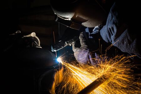 Workers are grooving with carbon welding wires With sparksの写真素材