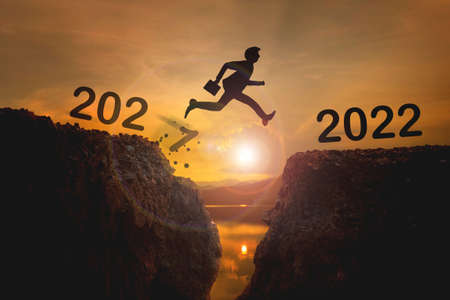 2022,Welcome Merry Christmas and Happy New Year 2022 Silhouette Man jumps from the cliffs of 2021 to...