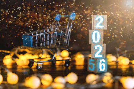 Happy New Year and shopping concept banner for 2026. Flip calendar with numbers 2025 to 2026 on wooden cubes, isolated on a bokeh background.の写真素材