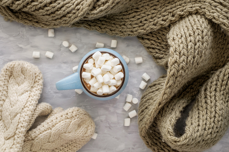 Christmas and New Year cozy holiday composition with scarf, mittens, mugs with cocoa or chocolate, marshmallow on the gray concrete background. Flat lay, top view.の写真素材