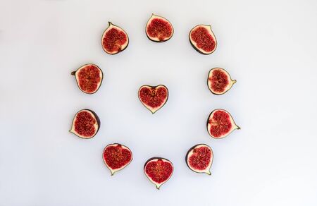 Pattern of ripe figs in the form a circle with heart isolated on white background. Fruit...
