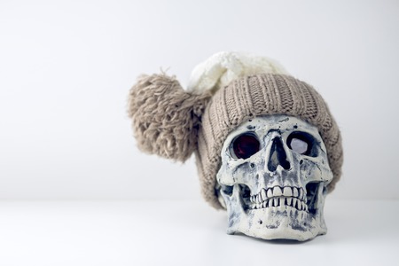 Halloween human gray skull imitation in warm knitted hat on head. Decorating for holiday Halloween. Concept of eternal holiday.の写真素材