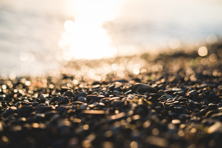 Small stones by the sea with bokeh effect.の写真素材