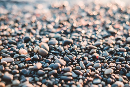 Small stones by the sea with bokeh effect. Blurred decorative vacation and holidayの写真素材