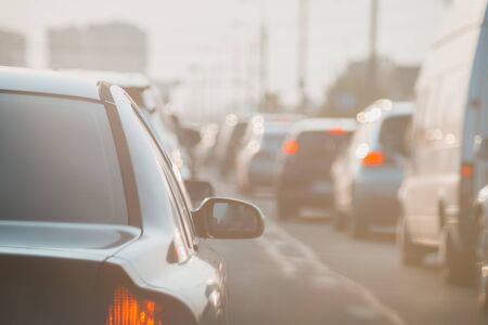 The back of an unknown car at sunset on road in heavy traffic.の写真素材