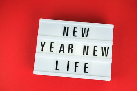 Light box with the inscription New Year New Life on bright red background. Preparing for Christmas and beginning of holidays.の写真素材