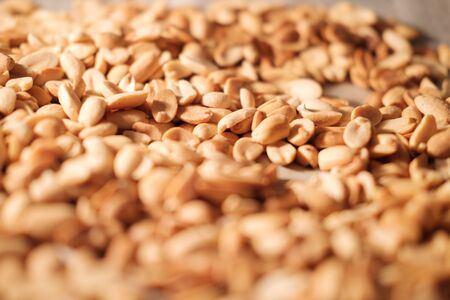 Peanut beans are fried on baking sheet and parchment paper in the oven. Preparing to make homemade...