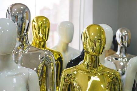 White, black, golden, silver mannequins stand in a row one after another.の写真素材