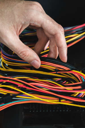 Young man repairs a computer system unit, changes parts, video card and hard drive, sets new...