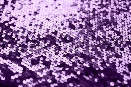 Sequin fabric texture. Shiny silver sparkling background. Clothing piece of glitter metallic for a glamorous party, celebration. Close-up. Toned image.の写真素材