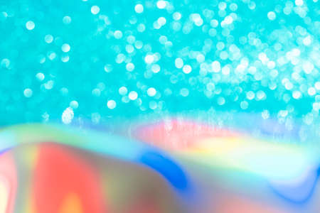 Abstract mixed holographic blue ai aqua blurred glitter shiny background. Liquid neon rainbow foil unicorn style. Bright sparkling bokeh style. Festive Christmas holiday iridescent futuristic textureの写真素材