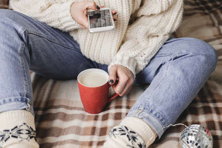 Female hand with smartphone takes pictures of New Year's or Christmas flatlay for social networks....
